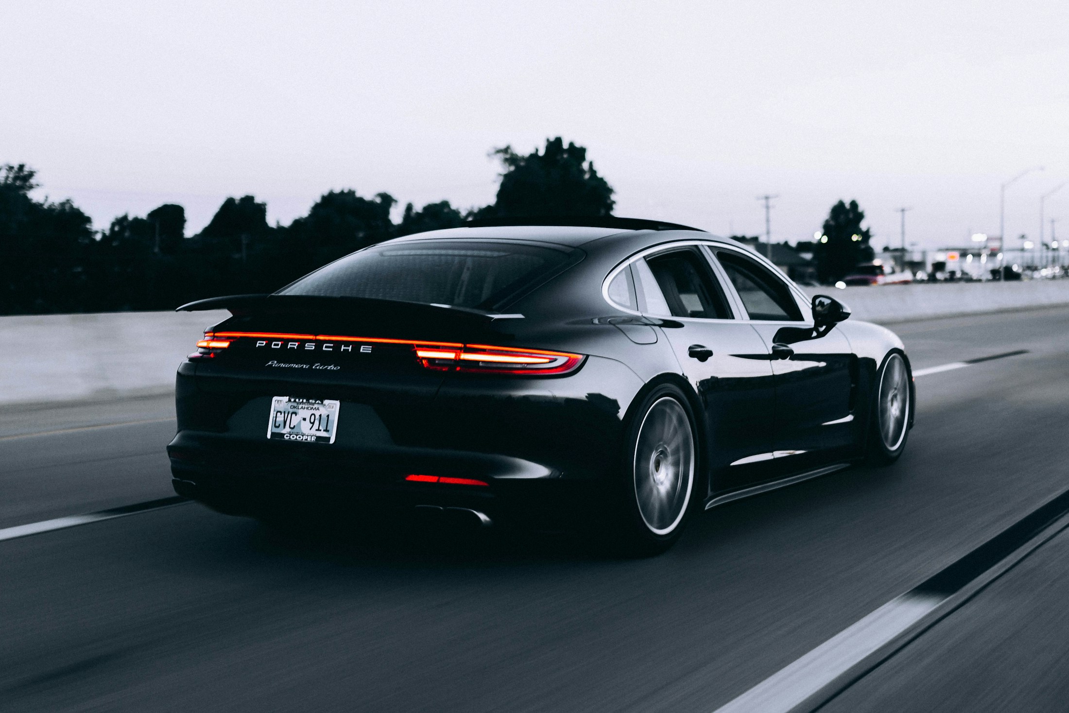 Silver sports car on a quiet, tree-lined road